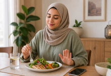 امرأة محجبة تجلس أمام طبق طعام صحي وتستعد للأكل على مائدة منزلية